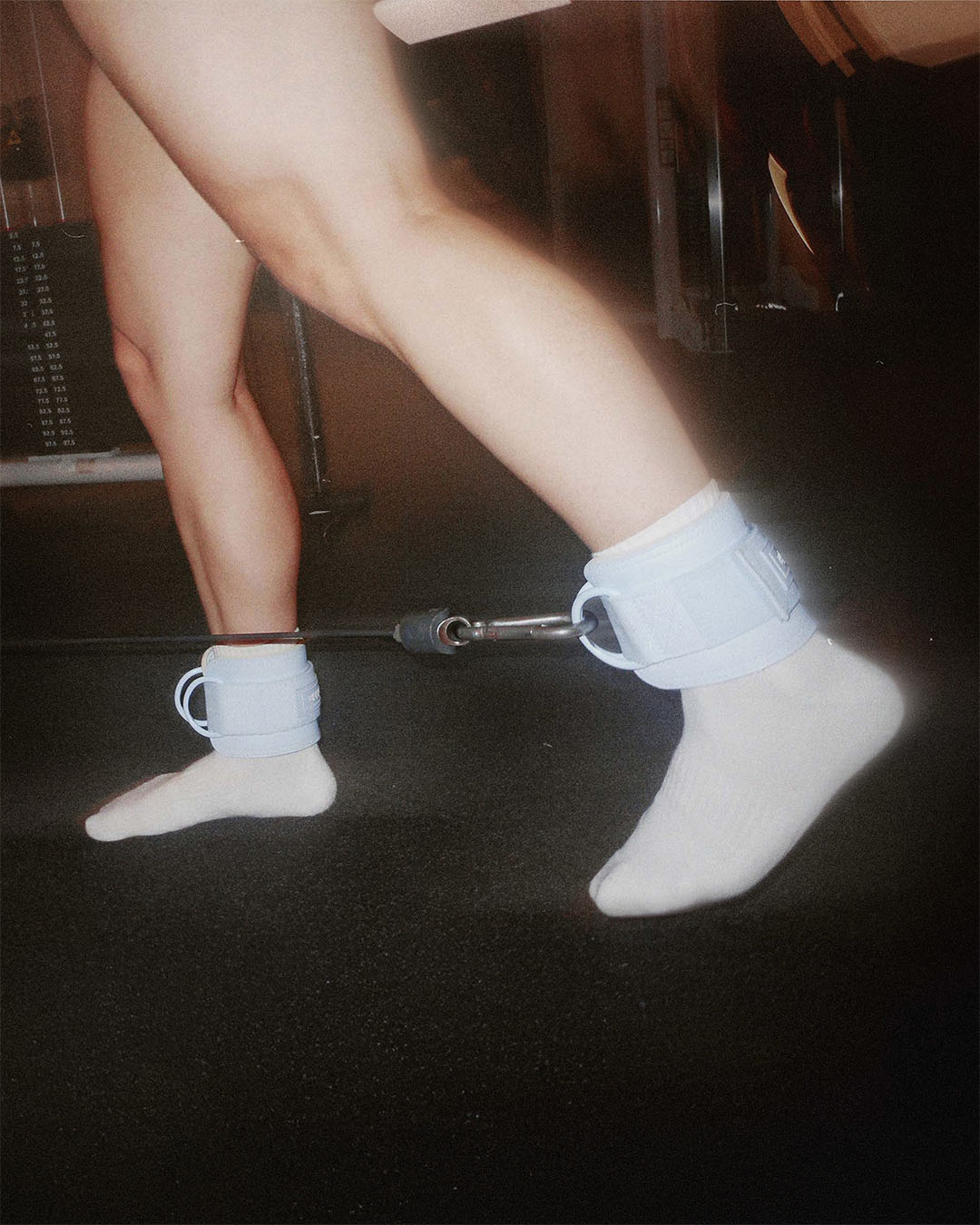 woman doing single leg exercise with uppper ankle straps