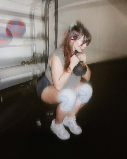 woman wearing knee sleeves and doing deep squat