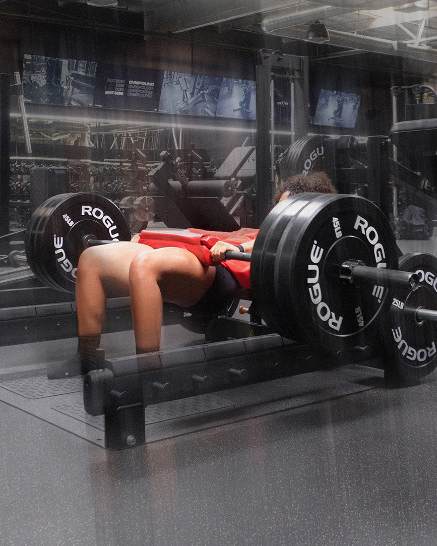 woman doing heavy hip thrust with uppper barbell pad