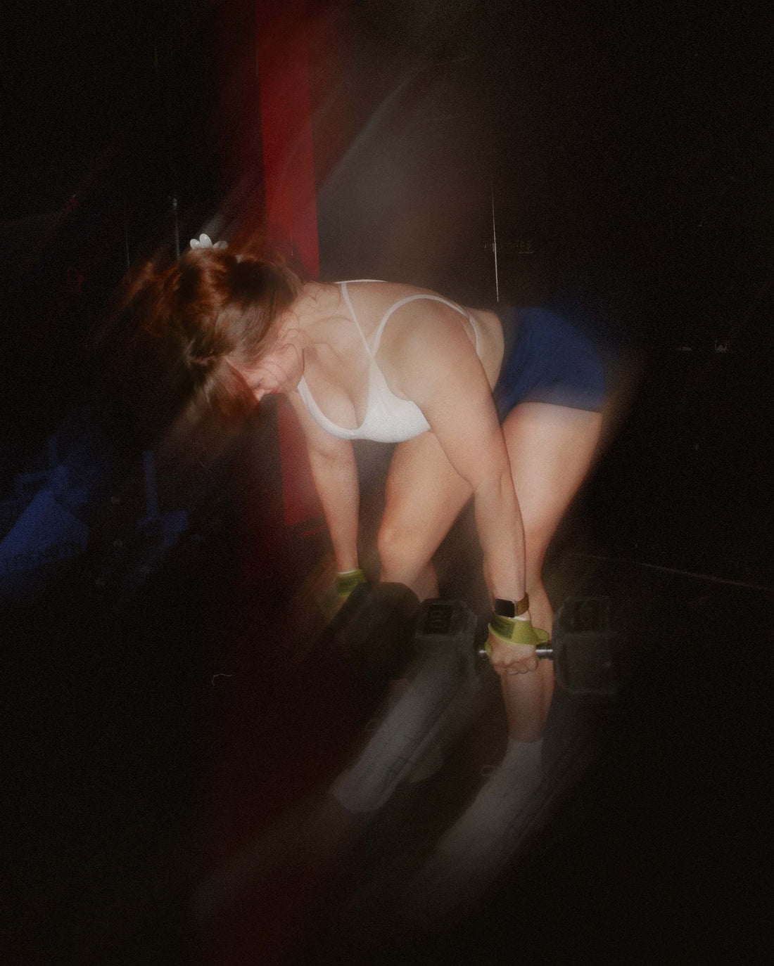 woman doing supersets wearing uppper lifting straps