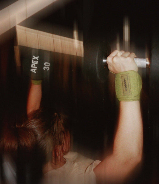 woman doing a shoulder press wearing uppper wrist wraps